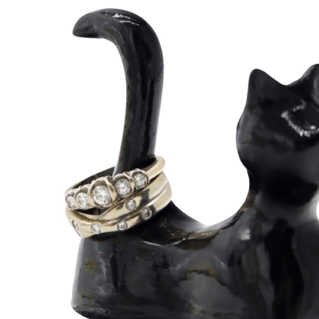 Close-up of rings on the raised tail of a hand sculpted black cat ring holder