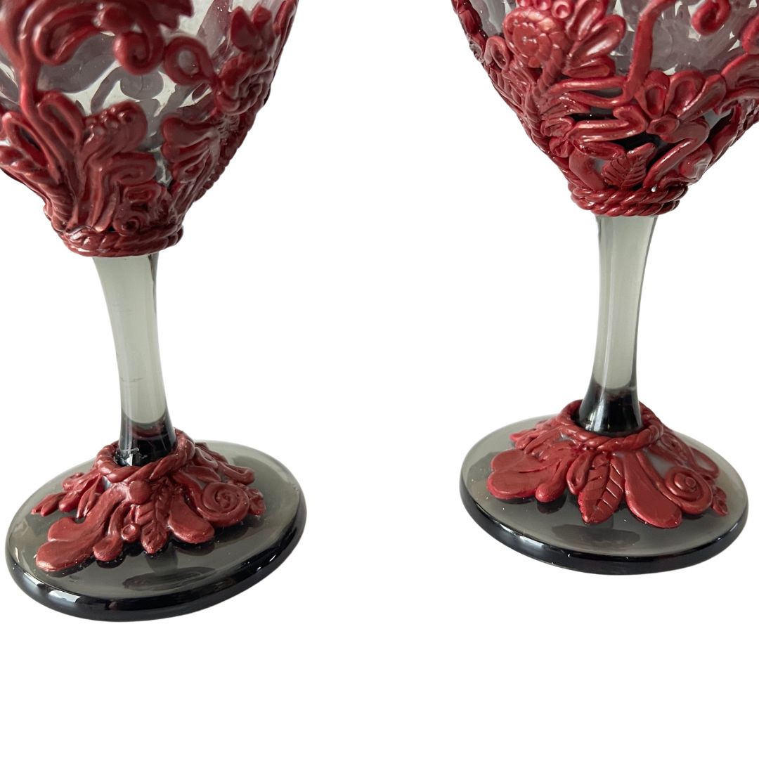 Close-up of intricate hand sculpted burgundy flourish details on wine glasses