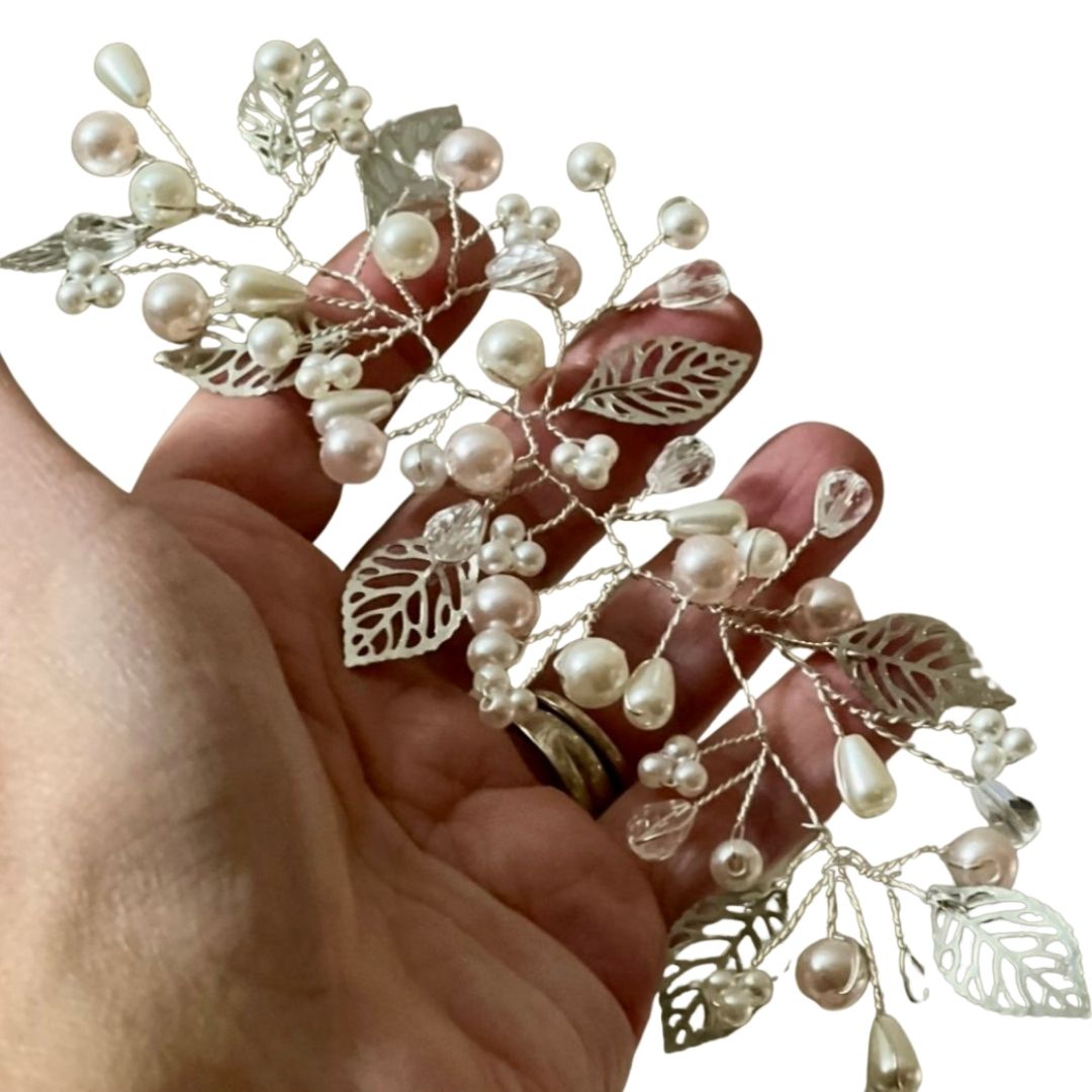 Close up of pearl and crystal bridal hair vine with silver metal leaves detail