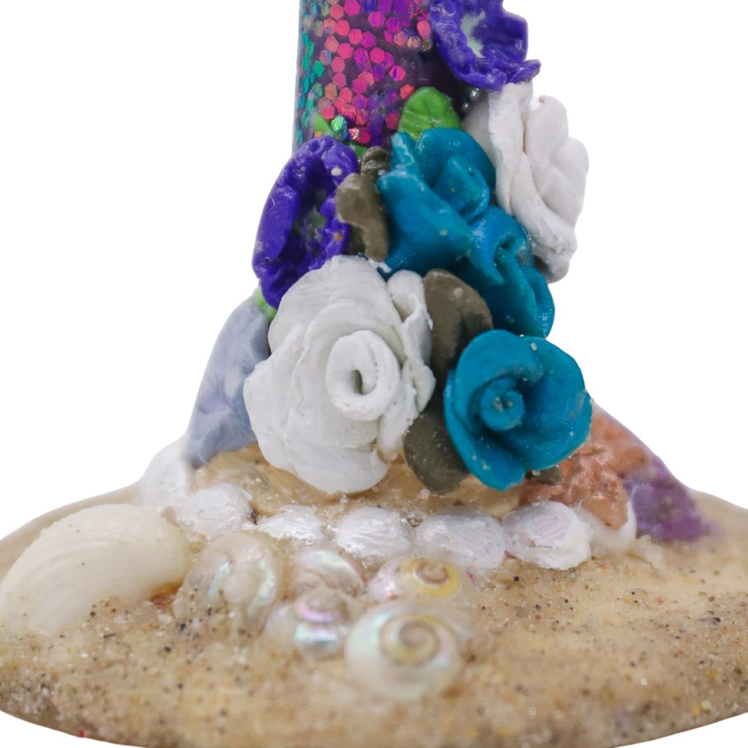 Closeup view of handmade champagne flute base with real seashells and colorful tropical flower stem.