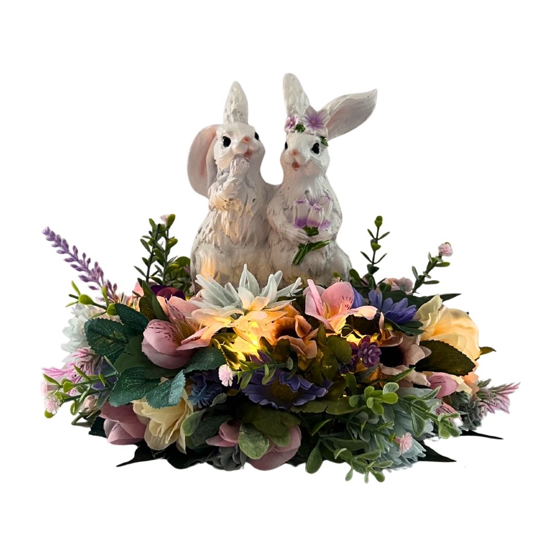 Lighted Easter bunny centerpiece with resin bunnies, pastel flowers, greenery, and carrot-shaped fairy lights