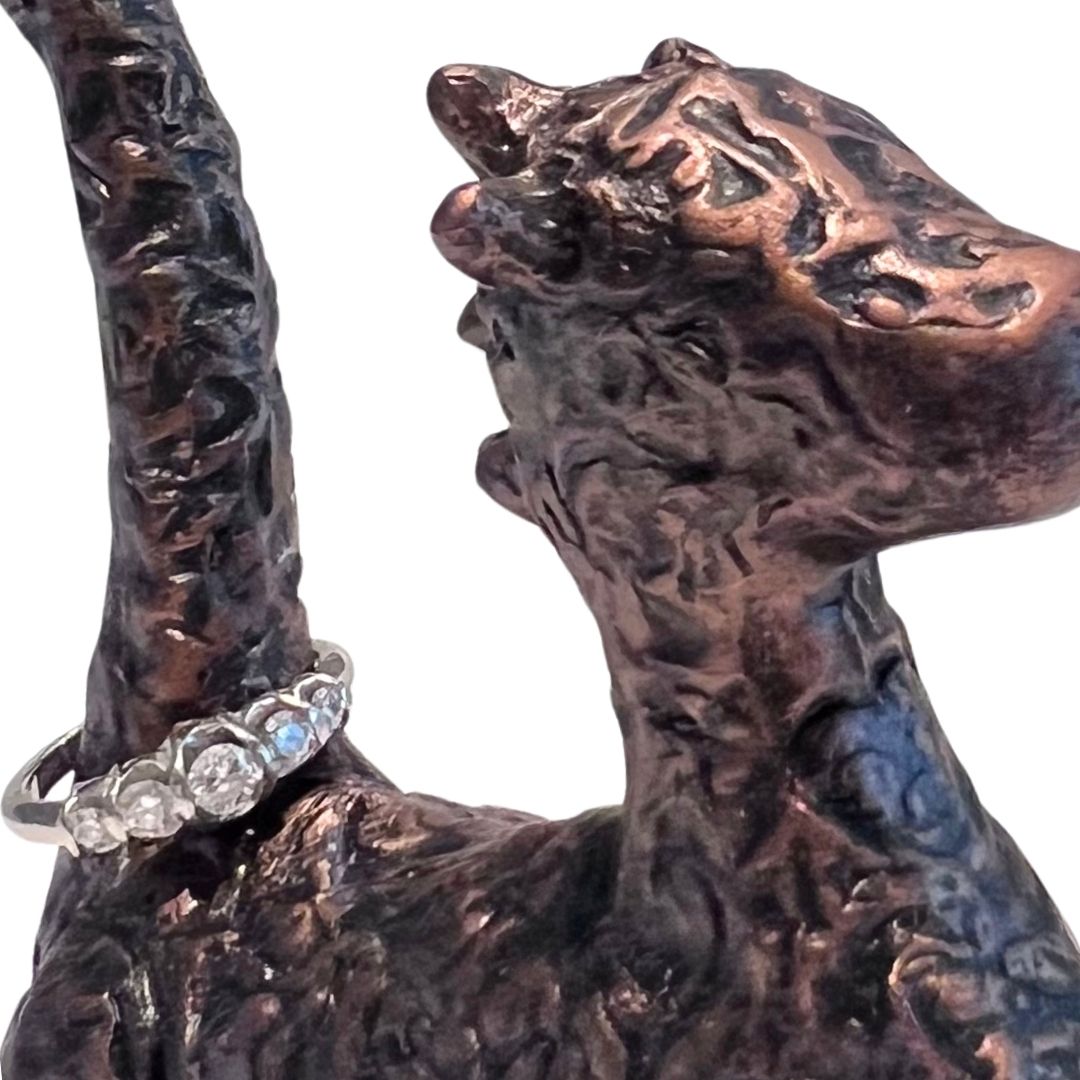 Hand sculpted bronze toned dragon ring holder with textured details and ring displayed on the tail