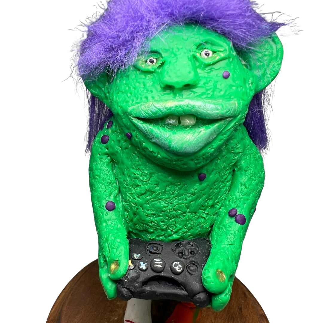 Close-up of Game On’s expressive face, purple hair, textured green skin and handmade game controller.