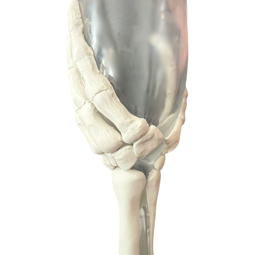 Close-up of skeleton hand champagne flute in progress, showing polymer clay sculpting details before finishing, handcrafted gothic glassware design

