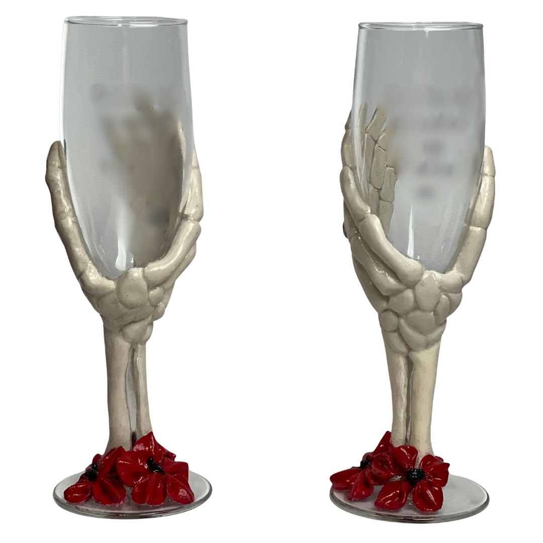 Set of gothic skeleton hand champagne flutes with red floral accents at the base, handcrafted polymer clay alternative wedding toasting glasses