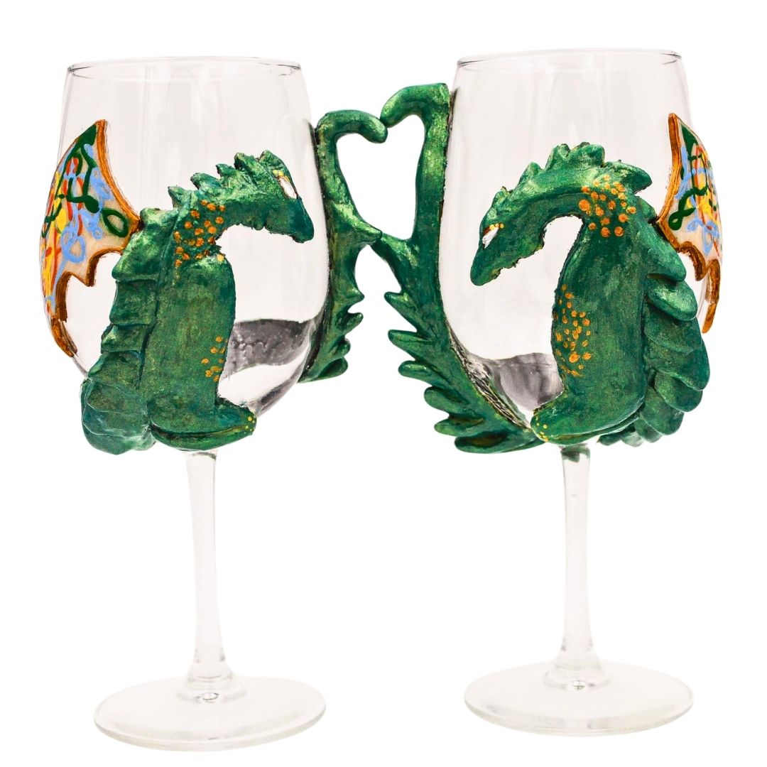 Hand sculpted green dragon wine glasses with polymer clay detailing, featuring textured dragon bodies and painted wings on clear stemware