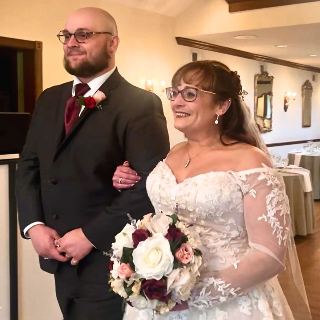 Bride carrying handmade Victorian silk rose bouquet in burgundy and cream on wedding day