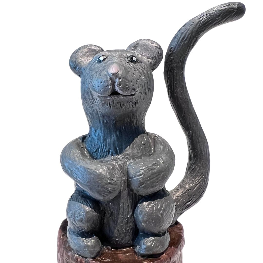 gray mouse ring holder holding a ring on its tail hand sculpted from polymer clay on a wood stump base