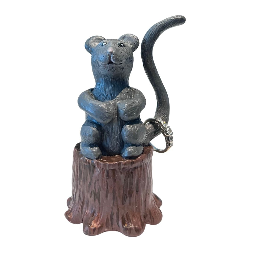 gray mouse ring holder holding a ring on its tail hand sculpted from polymer clay on a wood stump base