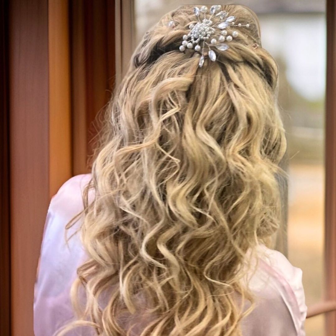 Ivory pearl and crystal bridal hair pin styled in blonde half up curly hairstyle near window light

