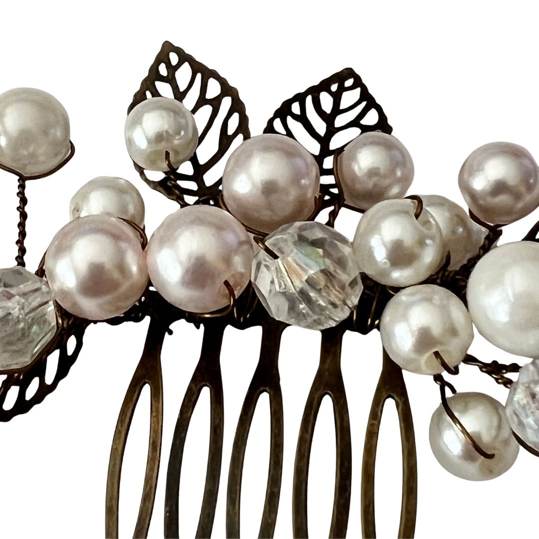Detail of ivory and blush pearls and faceted crystals on antique brass bridal hair comb