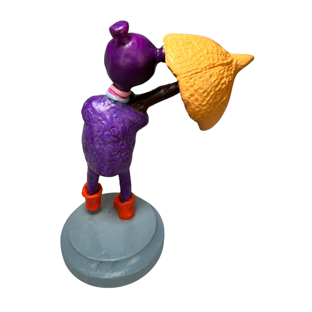Back view of Rainy Day Joy showing textured purple skin, yellow umbrella, orange boots and gray wooden base.