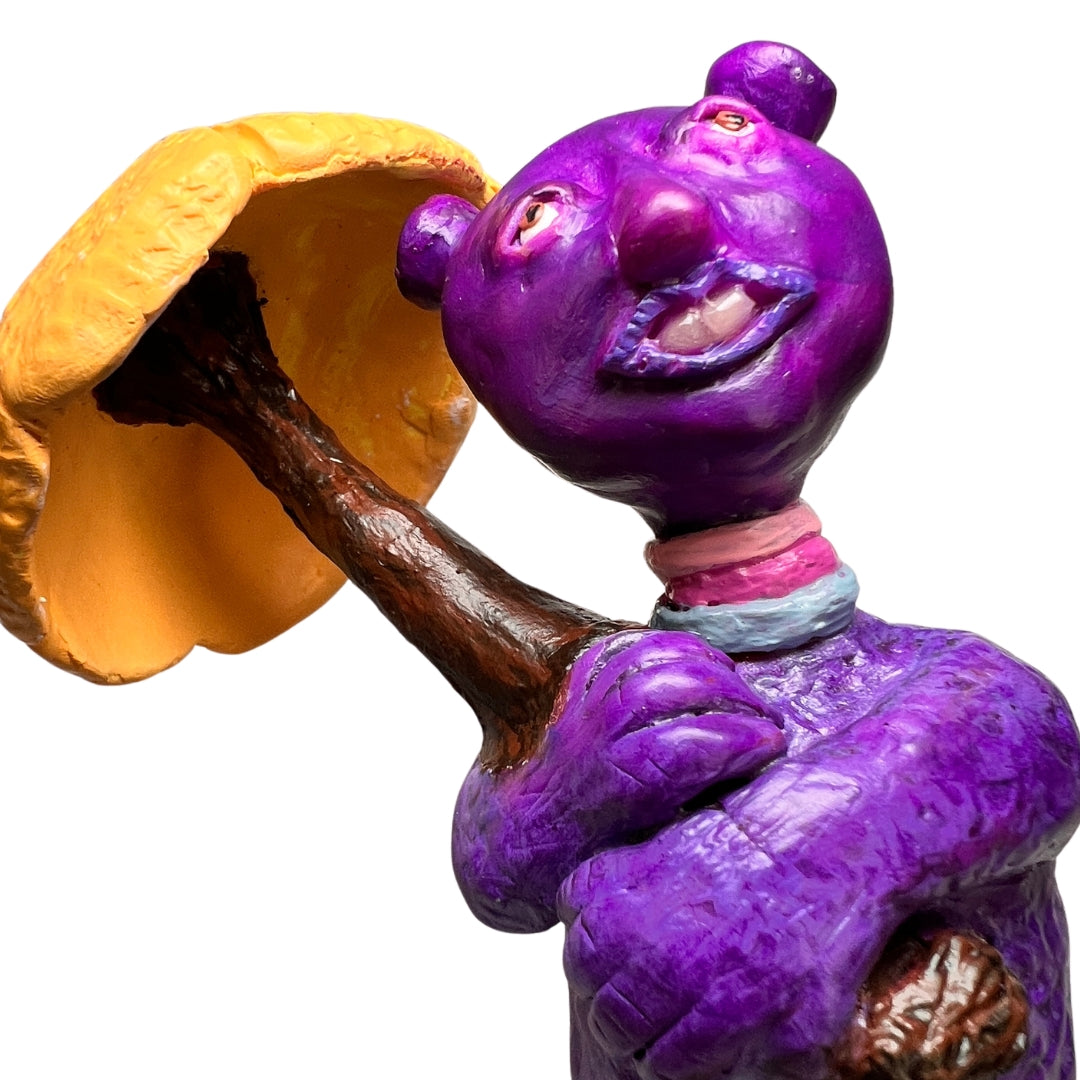 Close-up of Rainy Day Joy smiling beneath the handmade yellow umbrella with folded purple hands.