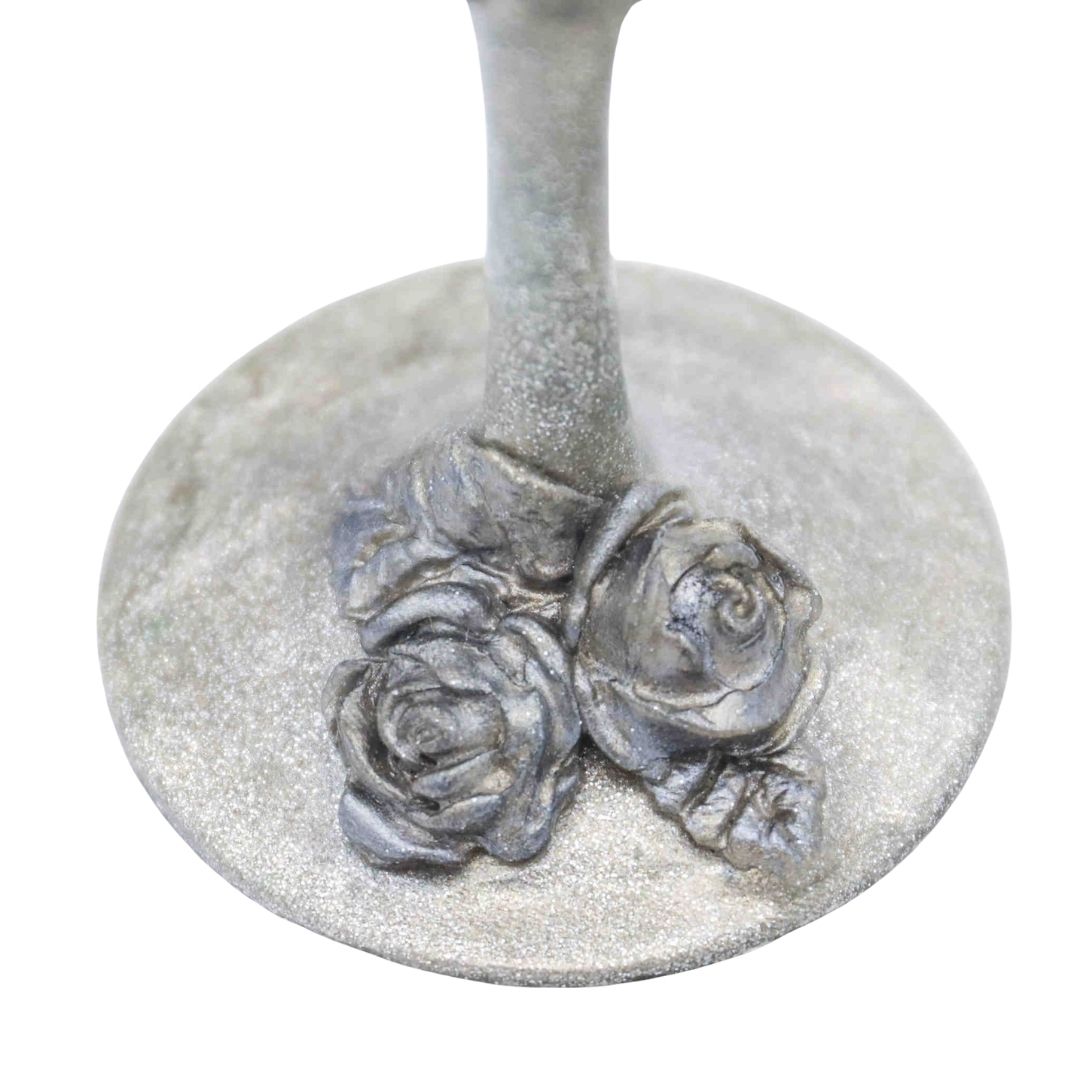 Hand sculpted silver roses at the base of a metallic Victorian style champagne flute