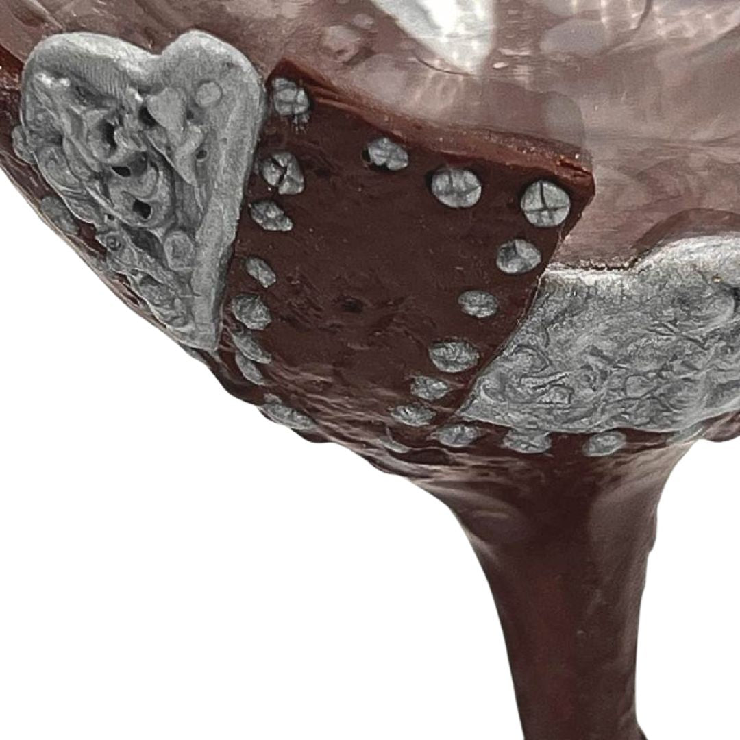 Close-up of steampunk wine glass with hand sculpted polymer clay panels, silver stitching details, and textured metal elements by Daree’s Designs
