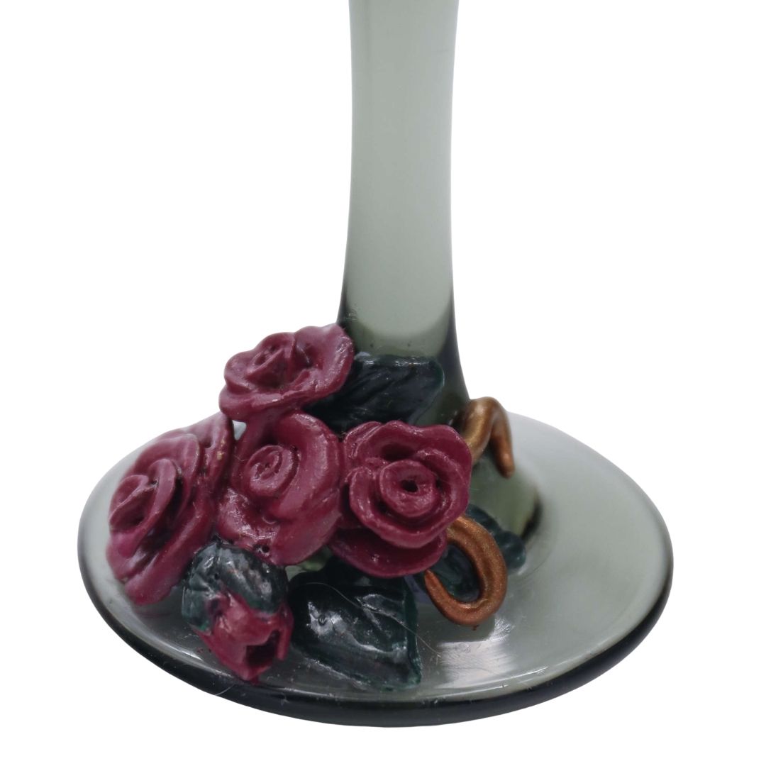 Close-up detail of burgundy sculpted roses and copper vine accents on the base of a Victorian-inspired wine glass.