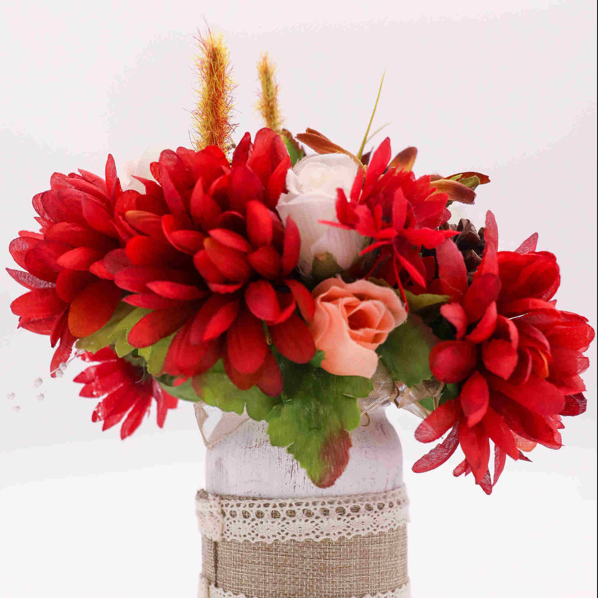 Add the feeling of Autumn to your celebration with our Autumn Mason Jar Centerpiece. This rustic mason jar centerpiece is the perfect compliment to an Autumn wedding. Adorned with burlap and lace, the mason jar holds seasonal silk flowers.