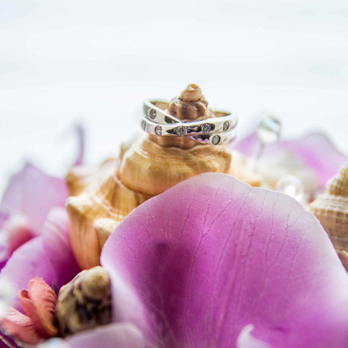 Bring the beauty of the beach to your tropical wedding ceremony. This cascading bouquet is adorned with various shells, silk orchids, ribbon, greenery and crystal bead stems.