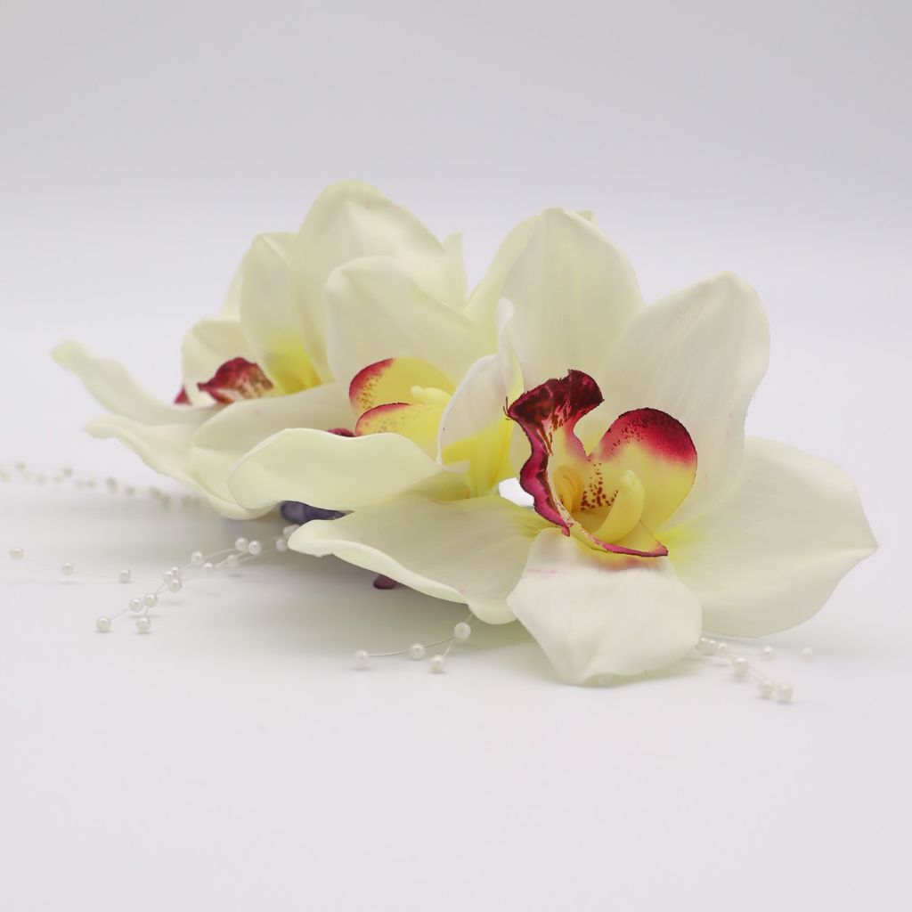 Using traditional techniques and fine craftsmanship, this lightweight, handcrafted hair piece is made from silk orchids and clear shimmer, which sit atop a comb to keep it in place during your festivities.