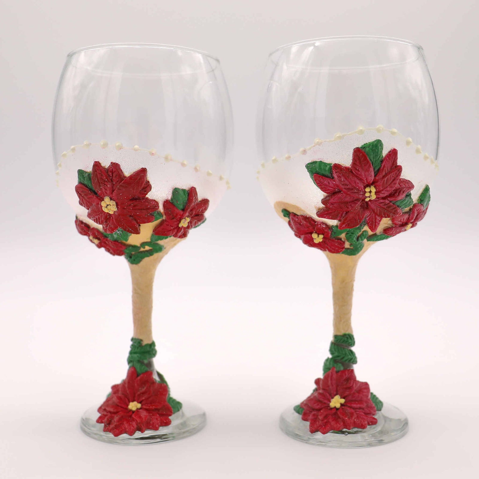 Perfect for any Christmas themed wedding or event, our Poinsettia Wine Glasses are perfect for yourself or as a gift.  Each wine glass sits atop a hand-scuplted polymer clay painted stem of red poinsettias, complimented with soft shimmery magical glitter.