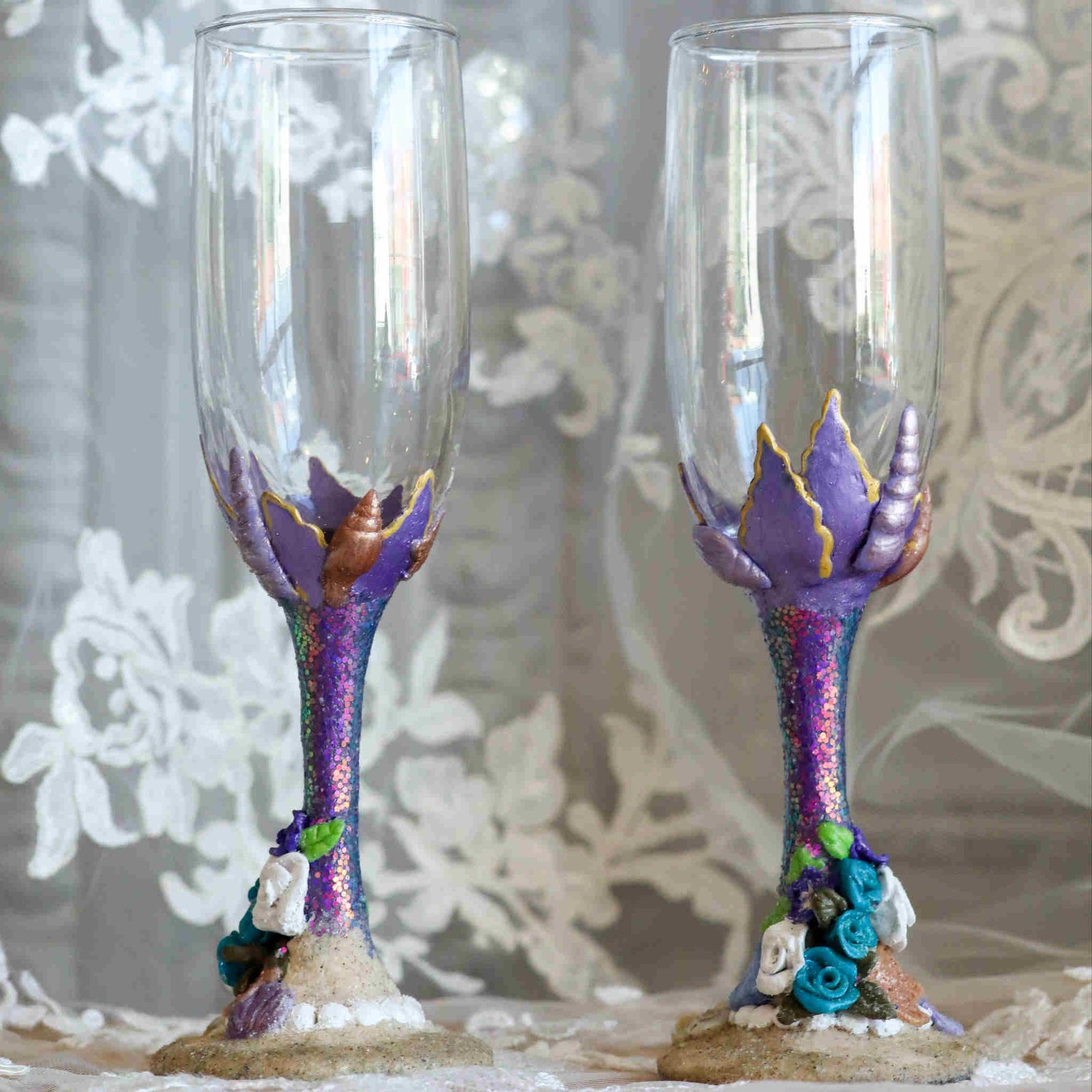 Enjoy the sea and sand while you toast to each other on your special wedding day or wedding anniversary. Each flute is hand-scuplted and painted with purple, teal, and white tiny seashells and flowers using polymer clay and sealed to last.