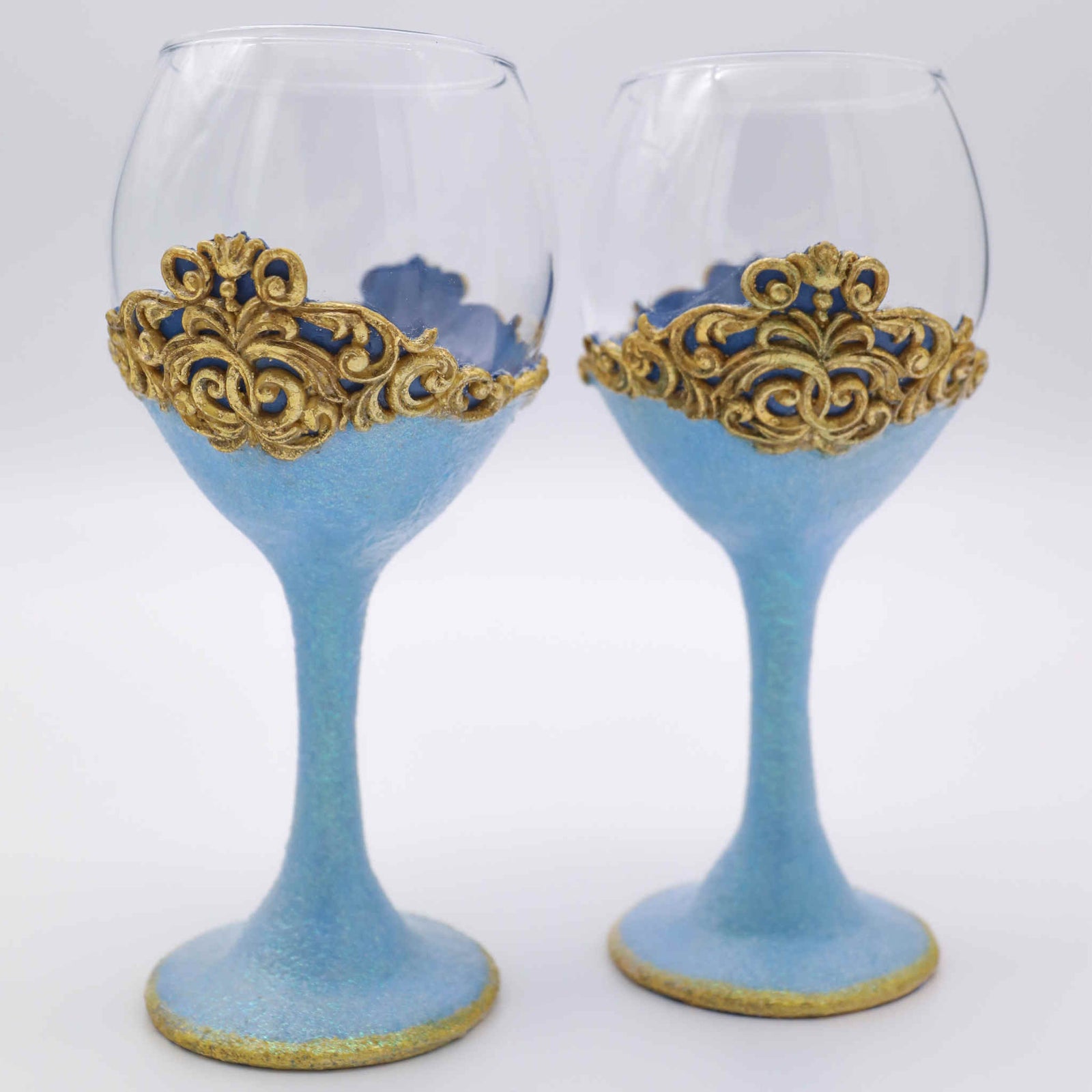 Add a touch of fairytale splendor and enchanted romance with our steamware set. It is the perfect way to add a little sparkle and a special touch of color. Makes a wonderful gift for engagements, showers, weddings and anniversaries. Each wine glass is hand-scuplted with polymer clay blue base and stem that shimmers with a touch of glitter. A gold leaf accents the bottom edge and "lace" top.