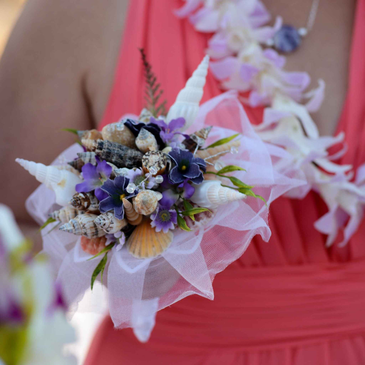 Bring the beach to your summer or tropical wedding ceremony set in greenery and adorned with cone shells and small silk flowers.