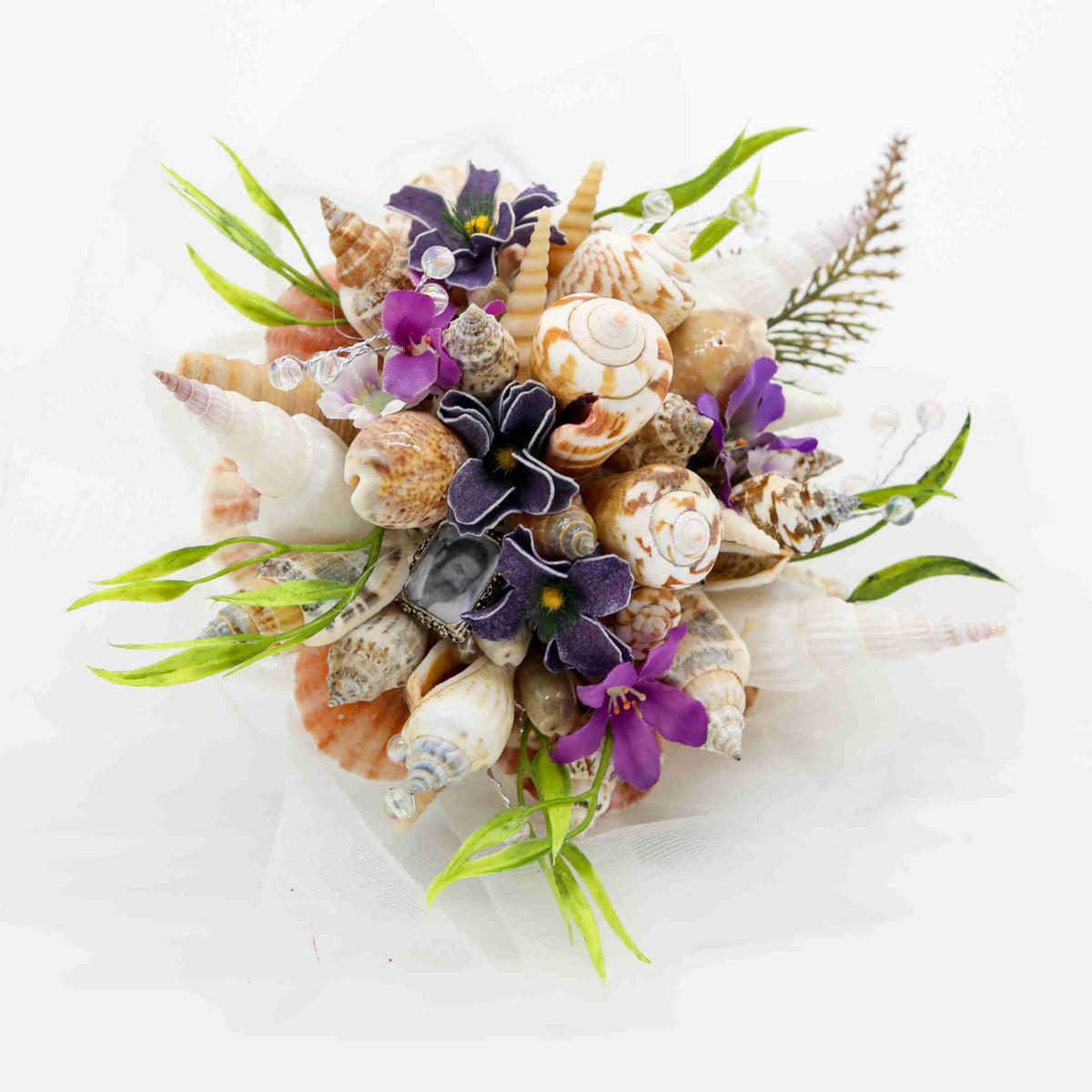Bring the beach to your summer or tropical wedding ceremony set in greenery and adorned with cone shells and small silk flowers.