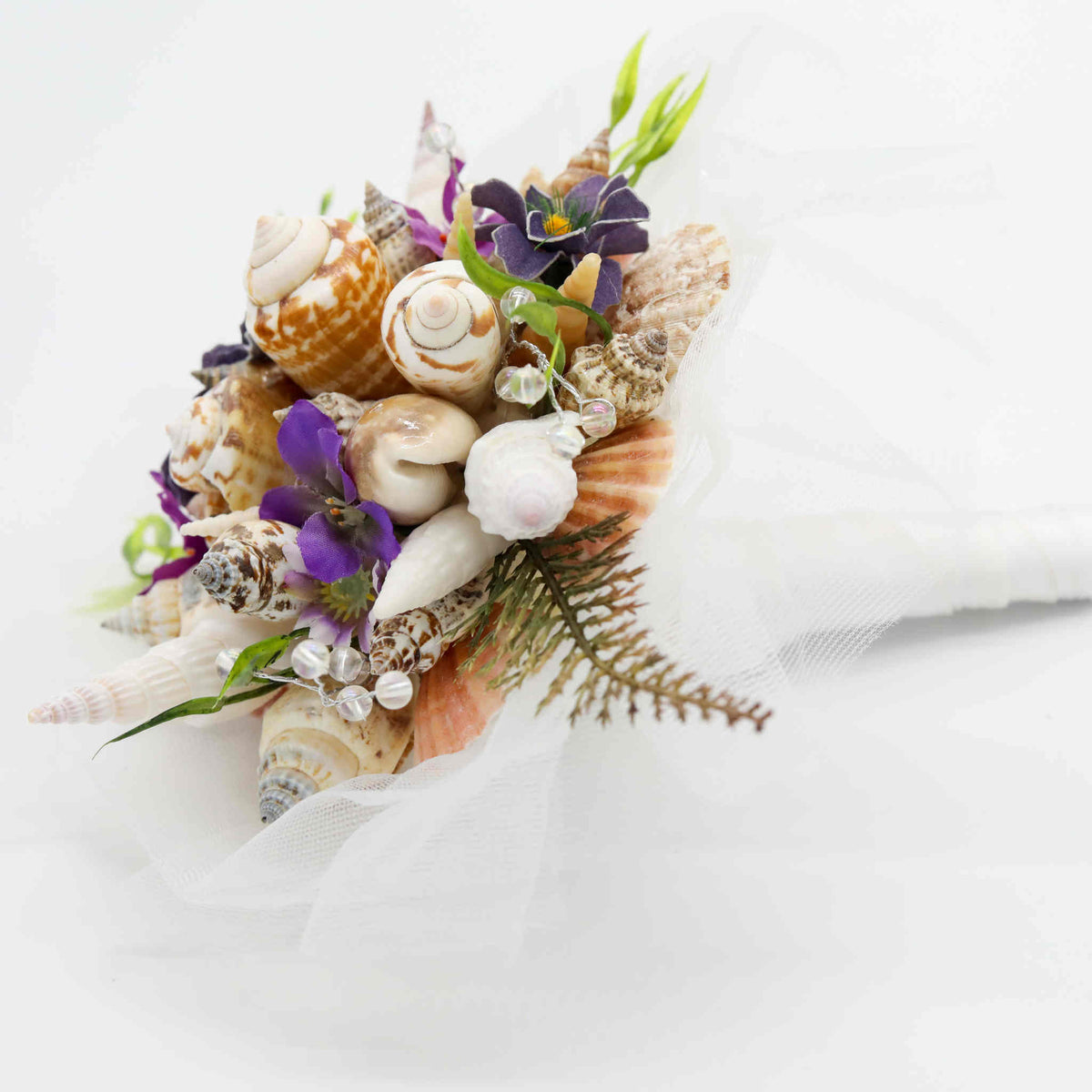 Bring the beach to your summer or tropical wedding ceremony set in greenery and adorned with cone shells and small silk flowers.