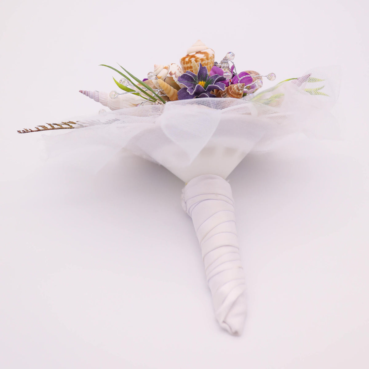 Bring the beach to your summer or tropical wedding ceremony set in greenery and adorned with cone shells and small silk flowers.