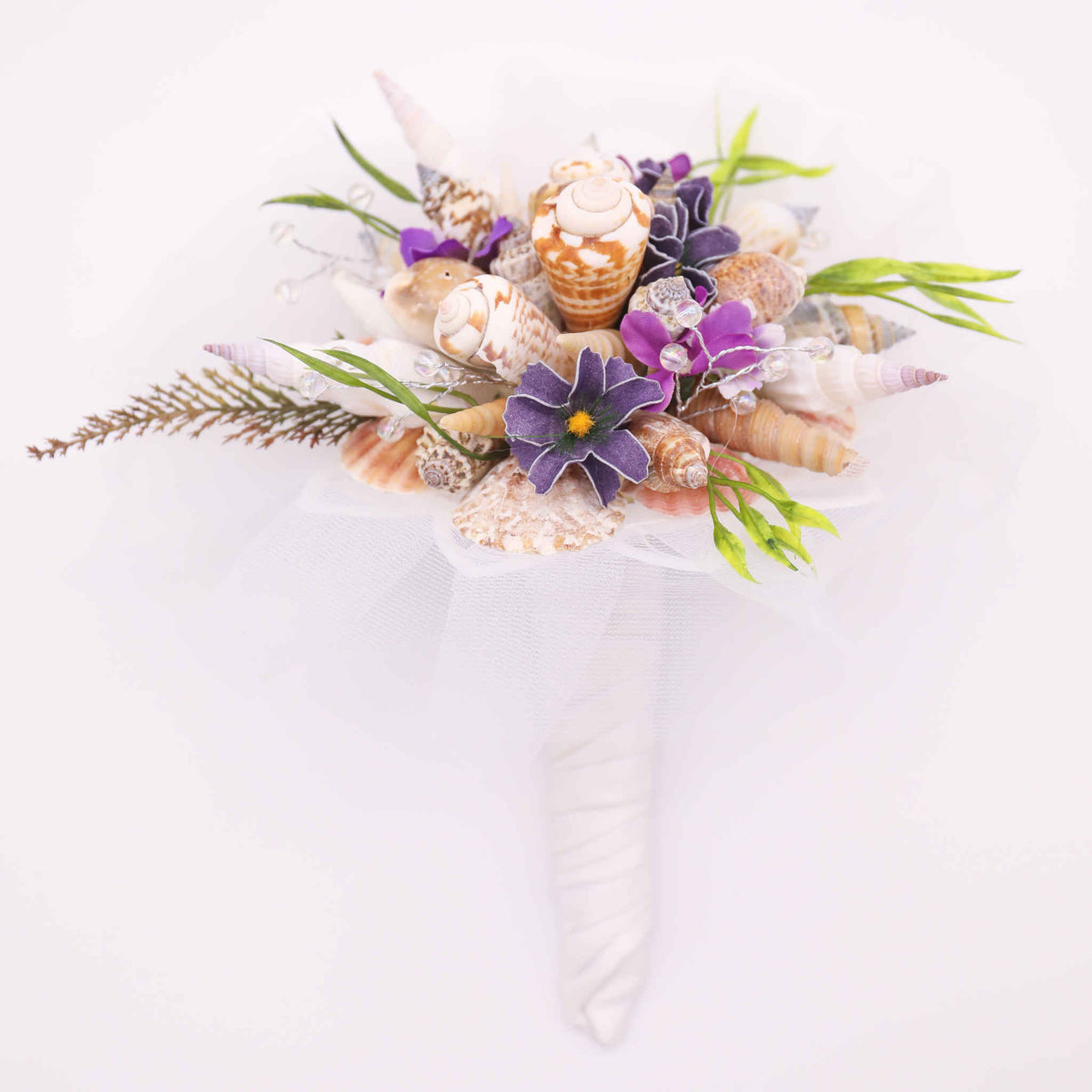 Bring the beach to your summer or tropical wedding ceremony set in greenery and adorned with cone shells and small silk flowers.